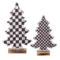 two black and white checkered christmas trees on wooden bases, one is made out of wood