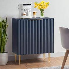 a blue cabinet sitting next to a potted plant