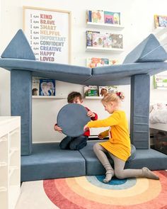 two children playing in an inflatable bed with a giant blow up house on the floor