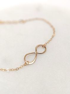 "Our gift to you 10% off your first purchase. Details here - http:/eepurl.com/dpVPBz A meaningful charm bracelet. The dainty infinity symbol is suspended from our signature dainty but strong chain. Ideal for everyday wear and makes a thoughtful gift for that someone special. DETAILS 14 k fill or Sterling Silver Infinity charm measures 3/4\" Beautiful and dainty chain Comes with a 1\" extender chain to fine tune your fit This listing is for one infinity bracelet only FIND THE PERFECT FIT - MEASUR Hypoallergenic Rose Gold Infinity Jewelry, Mother's Day Infinity Jewelry With Adjustable Chain, Personalized Infinity Jewelry For Her, Personalized Infinity Jewelry Gift For Her, Infinity Jewelry For Mother's Day, Adjustable Infinity Jewelry For Bridesmaid Gift, Elegant Infinity Jewelry For Friendship, Minimalist Infinity Bracelet With Adjustable Chain, Adjustable Infinity Jewelry For Mother's Day