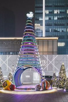 a large christmas tree is lit up in the city