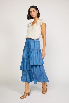 This chambray asymmetrical tiered midi skirt features an elastic waistband for a comfortable and adjustable fit. Its quality construction and fabric provides maximum durability, perfect for everyday wear. The varied length tiers create a flattering silhouette for any body shape. •Relaxed fit •A Line Cut •Tiered Detail