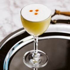 a glass filled with liquid sitting on top of a metal tray