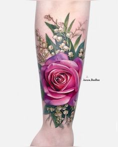 a woman's leg with flowers and leaves on it