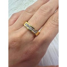 a woman's hand wearing a gold ring with two diamonds on it and the band is