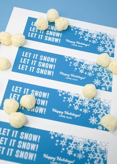 three snow themed candy bar wrappers sitting on top of a blue and white table