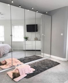 two children laying on the floor in front of a mirrored wall with mirrors and lights