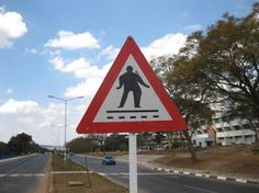 a red and white street sign sitting on the side of a road