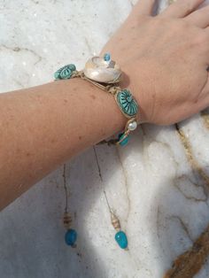 Beautiful Natural Shell Hemp Macrame Bracelet, Macrame Shell Turquoise Boho Bracelet, upcycled paper bead shell adjustable bracelet, beach boho chic... For this beautiful spiral Seashell hemp Macrame beaded Bracelet, I used a unique mix of media... This is a one-of-a-kind jewelry piece. . .. A spiral sea shell that I found on the beach here in Santa Cruz, California is woven into hemp macrame cord with genuine Kingsman turquoise, hand made and laquered (upcycled calendar) paper art beads, vintage glass teal seashell beads and pearlized white beads. I wove all of them together by hand knotting hemp into this adjustable macrame bracelet.  Lanyard style closure will slide to adjust to fit most wrists. At its smallest it measures 7.5 inches long, and at its largest it measures 10 inches. Very Bohemian Bracelet With Adjustable Cord, Adjustable Macrame Bohemian Friendship Bracelets, Bohemian Strand Bracelets With Sliding Knot, Artisan Blue Bracelets For The Beach, Unique Beach Jewelry With Adjustable Cord, Bohemian Macrame Adjustable Bracelets, Adjustable Macrame Bohemian Bracelets, Adjustable Bohemian Macrame Bracelets, Turquoise Bohemian Braided Bracelet For Gift