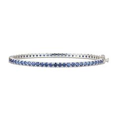 Gorgeous round blue lab-created sapphires adorn this sophisticated bangle fashioned in classic sterling silver. The bracelet measures 7.25 inches and secures with a box clasp. Elegant Blue Stackable Jewelry, Blue Fine Jewelry Bangle For Gifts, Timeless Blue Bracelet For Formal Occasions, Classic Blue Stackable Jewelry, Classic Gemstone Bangle For Anniversary, Fine Jewelry Sapphire Bangle Bracelet, Silver Sapphire Bangle Bracelet, Classic Sapphire Stackable Jewelry, Classic Stackable Sapphire Jewelry