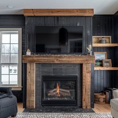 a living room with black walls and a fireplace