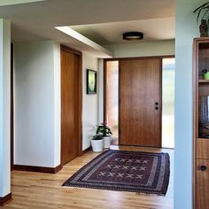 an entryway with wooden doors and potted plants