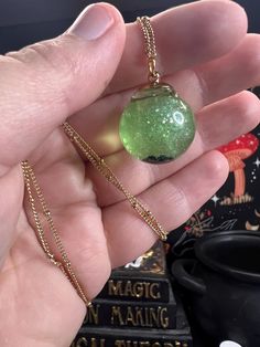 Step into a world of magic and whimsy with my unique liquid fidget jewelry! The light green shimmer, larger sparkles, and 5 tiny black pearls reminiscent of frog eggs will mesmerize your family and friends alike with the captivating swirls that come to life with your natural body movements!  The shiny "fairy dust" give these globes a magical allure. As it sits, the sparkles settle to the bottom to coat the tiny pearls at the bottom of the globe. When you give it a gentle shake, watch in awe as it comes alive with mesmerizing swirls of color. Truly captivating in direct sunshine, the camera just can't capture how mesmerizing the swirls are!  These are lovingly made by hand to order; slight variations in color, density, and the UV resin seal shape are expected! My processing times can also b Whimsical Adjustable Iridescent Jewelry, Handmade Mystical Green Jewelry, Mystical Handmade Green Jewelry, Green Handmade Mystical Jewelry, Handmade Green Mystical Jewelry, Magical Gold Jewelry For Party, Handmade Magical Iridescent Jewelry, Handmade Iridescent Magical Jewelry, Mystical Iridescent Jewelry For Gifts