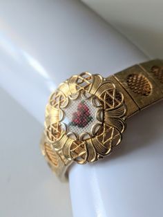 Unique and charming Vintage 1960s gold tone metal bracelet with a watch-like appearance, but the centre of the "face" is a petit point flower. Not a watch at all! Fold over clasp.  Approximate wearable length: 7 1/8" "Face" is approx 1" diameter  Very good vintage condition! Minor wear, all components appear to be intact and functional! Compact Makeup, Accessory Inspo, Vintage Compact, Metal Bracelet, Metal Bracelets, Vintage 1960s, Fold Over, Chain Link Bracelet, Gold Tone Metal