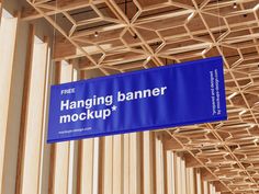 a blue sign hanging from the side of a wooden structure that reads hanging banner mockup