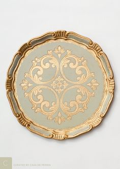 an ornately decorated gold plate on a white background