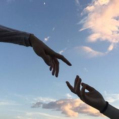 two hands reaching out towards each other in the sky