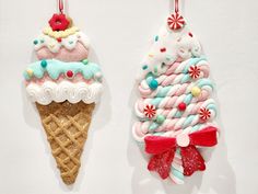 two ice cream sundaes hanging from hooks on a white wall with candy canes and sprinkles