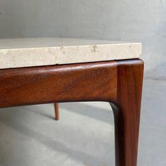 a close up of a wooden bench with marble on it's top and bottom