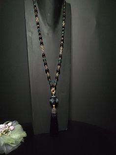 Beautiful sautoir necklace with long tassel. The main elements of this necklace are two: a large 30 mm pearl covered in beads and crystals and a splendid black tassel with Marcasite. These crystals give a lot of brightness and make the necklace very elegant. The pearl is covered by hand with different types of beads, a precision and difficult job to perform. The necklace is made with black agate beads of different sizes and crystals. Some points are highlighted with the beautiful emerald green color which gives a mystical look to the necklace. Everything matches perfectly, colors and shapes. The closure is an 18K gold-plated opening ring. The pendant with the ball and the tassel can be removed if desired and you can only wear the simple necklace. The necklace is very elegant, perfect for l Elegant Necklace With 108 Beads For Gift, Elegant Necklace With 108 Beads Pendant, Elegant Handmade Black Long Necklace, Elegant Necklace With 108 Beads For Party, Elegant Party Necklace With 108 Beads, Elegant Handmade Tassel Necklace With Round Beads, Elegant Long Necklace With Large Beads, Elegant Black Tassel Necklace For Party, Elegant Jewelry With Tassels And Round Beads