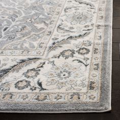 a large rug with an ornate design on the top and bottom in grey, beige and white colors