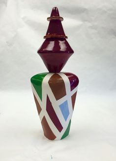 a colorful vase sitting on top of a white table