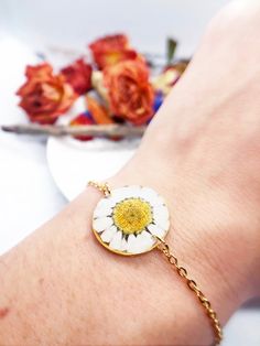 a woman's arm with a flower bracelet on it