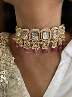 Discover the epitome of elegance with our premium choker set. Crafted with precision and designed to turn heads, this set is a true masterpiece. Product Details: Material: Each piece is meticulously handcrafted from high-quality brass, copper, gold plating, Kundan work CZ Stones, Peach Beads,  Choker Dimensions: Weight: 70 grams Closure Type: Premium Dori Adjustable Size: Yes Earring Dimensions (Per Pair): Weight: 16 grams Closure Type: Push Back  Exquisite Design: This set boasts a design that' Elegant Kundan Choker Necklace For Ceremonial Occasion, Elegant Festive Choker, Elegant Kundan Choker Necklace With Tilla, Elegant Kundan Choker Necklace For Formal Occasions, Elegant Kundan Choker For Formal Occasions, Elegant Hand Set Choker For Ceremonial Use, Elegant Formal Kundan Choker Necklace, Elegant Hand Set Choker For Ceremonial Occasions, Elegant Formal Kundan Choker