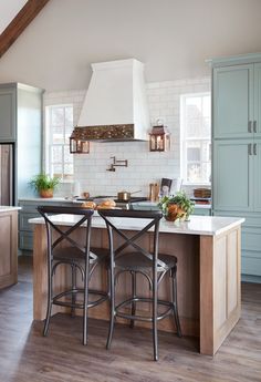 a kitchen with two stools at the island