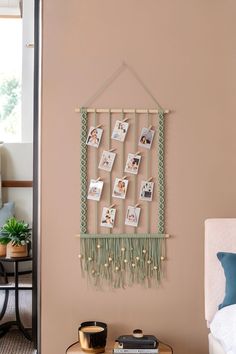 a wall hanging with pictures on it in a living room next to a coffee table