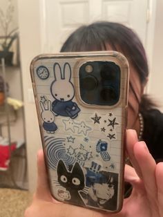 a person holding up a phone case with stickers on it