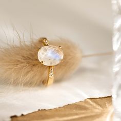 The Moonstone Ring (Serena) features an oval rainbow moonstone set on a gold tapered band. This elegant statement ring is flanked by cubic zirconia stones that shine brilliantly like diamonds. We love this ring because of its intriguing blue and white tones!


The rainbow moonstone measures 10mm x 8mm.
 Size: 4, 5, 6, 7, 8, 9, 10 Moonstone And Diamond Ring, Moonstone Gold Ring, Gold Moonstone Ring, Silver Rings For Women, Gold Vermeil Jewelry, Moonstone Engagement Ring, Big Rings, Moonstone Jewelry, Pretty Rings