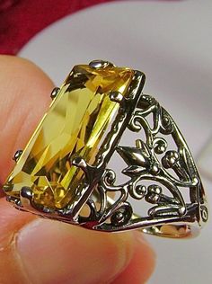 Yellow Citrine Ring Baguette Design#32 Introducing the Baguette D32, a stunning piece of wearable art that pays homage to the opulent Victorian era. Crafted with meticulous attention to detail, this exquisite filigree Antique reproduction in sterling silver is sure to captivate anyone with a love for vintage-inspired jewelry. At its center, lies a flawless 7ct yellow gemstone, radiating a dazzling hue that catches the light with every movement. The baguette rectangle-cut gemstone measures a rema Elegant Yellow Citrine Jewelry, Yellow Rectangular Stone Ring For Gift, Yellow Rectangular Stone Ring Gift, Rectangular Stone Yellow Ring Gift, Yellow Rectangular Gemstone Rings, Luxury Yellow Baguette Cut Jewelry, Formal Yellow Baguette Cut Jewelry, Yellow Citrine Rectangular Rings, Yellow Rectangular Citrine Ring