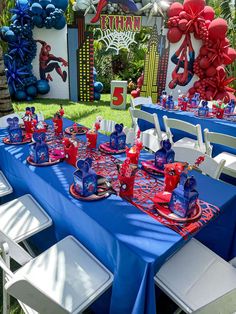 the table is set with red, white and blue decorations for spiderman birthday party