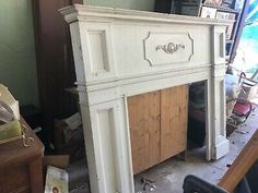 an old fireplace in the middle of a room with other furniture and items around it