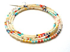 Ivory glass seed beads with stripes and 14k gold filled accents. The pieces can be worn as a wrap bracelet, necklace, or anklet. Measures 27". Adjustable White Waist Beads With Tiny Beads, Adjustable White Bohemian Waist Beads, Hand-strung Heishi Bead Jewelry For Summer, White Multi-strand Bracelets With Colorful Beads, White Heishi Beads Single Strand Jewelry, White Single Strand Bohemian Beaded Bracelets, White Bohemian Wrap Bracelet With Tiny Beads, Bohemian White Wrap Bracelet With Tiny Beads, Bohemian White Tiny Beads Wrap Bracelet