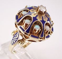 Antique 18K Yellow Gold Opal, Diamond and Blue Enamel Ring. The center Round Brilliant Diamond in this ring is H color, SI2 clarity and weighs .18 carat.  There are eight Round Opal set in this ring with Blue Enamel throughout. This ring is 18KT Yellow Gold, weighs 13.7 grams, measures 20 mm in diameter and 14 mm in height.  This ring is a finger size 7 1/4, can be resized. This ring will also be accompanied by an appraisal by a GIA Certified Diamond Grader with the replacement value of $7,295.00. I will ship this ring promptly in a beautiful gift box.    ADDITIONAL REQUESTS If you would like to see more pictures of this item, please let us know and we would be happy to provide them for you. Please contact us with all questions, we are here to help. Fine Jewelry Enamel Ring With 17 Jewels For Anniversary, Unique Yellow Gold Enamel Ring For Formal Occasions, Wedding Rings With Gemstone And Enamel, Enamel Gemstone Rings For Wedding, Yellow Gold Enamel Gemstone Ring For Wedding, Heirloom Yellow Gold Enamel Ring For Ceremonial Occasions, Traditional Blue Rings For Anniversary, Heirloom Ceremonial Enamel Ring In Yellow Gold, Unique Yellow Gold Enamel Ring For Anniversary