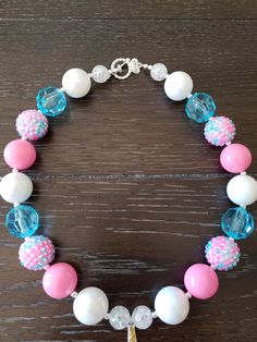 a bracelet with pink, white and blue beads