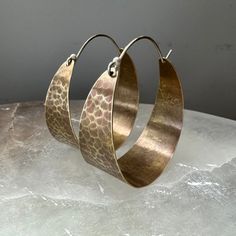 These sweet, wide brass hoops make great "every day" earrings. Hammered and oxidized, sterling ear wire fits into hole in back of hoop to close. Small - around 3/4" diameter Medium - 1 1/2" diameter Large - a little over 2" diameter Gold Electroformed Hoop Earrings, Unique Hammered Hoop Earrings, Hand Forged Bronze Small Hoop Jewelry, Hammered Copper Round Hoop Earrings, Hammered Copper Hoop Jewelry, Bronze Brass Hoop Earrings With Ear Wire, Artisan Nickel Free Copper Hoop Earrings, Bronze Hammered Hoop Earrings, Bronze Hand Forged Hoop Earrings