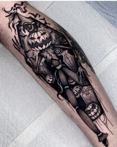 a black and white tattoo on the arm of a man with an evil clown holding a jack - o'- lantern