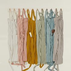 several different colored shirts hanging on a clothes line