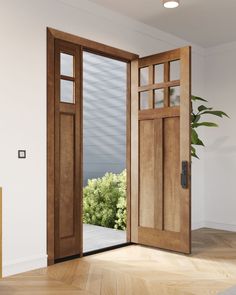 an open wooden door in a white room with wood flooring and potted plant