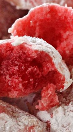 some red and white doughnuts with powdered sugar on top are shown in close up