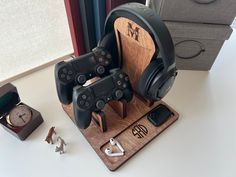 two video game controllers are sitting on a wooden stand next to some other items that have been placed around them