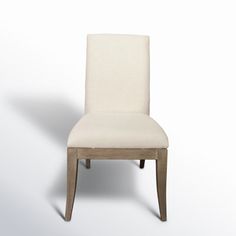 a white chair sitting on top of a white floor next to a wooden legrest