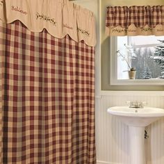 a bathroom with a checkered shower curtain next to a white sink and window sill