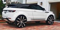 a white range rover parked in front of a house