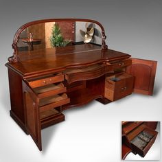 a wooden desk with drawers and a large mirror on top of it's side