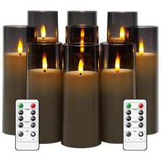 six lit candles with remote controls in front of them