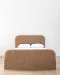 the bed is made up with two pillows on it's headboard and foot board